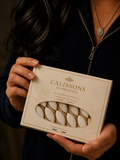 Boîte de calissons artisanaux de Provence aux amandes, tenue par une personne.