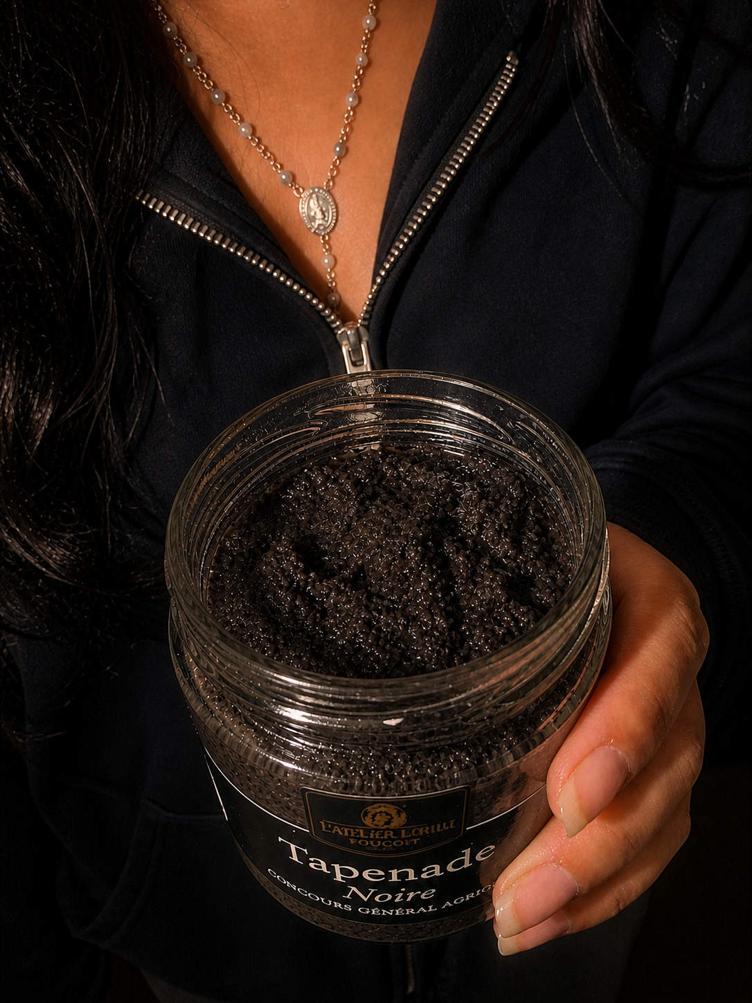 Pot de tapenade d'olive noire artisanale de Provence tenu à la main